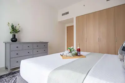 a bedroom with a white bed and a dresser at Frank Porter - Island Park 2 in Dubai