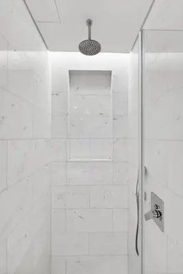 a white bathroom with a shower with a glass door at DVH Luxe Retreats at The Palm Tower, Palm Jumeirah, Studio Apartment in Dubai
