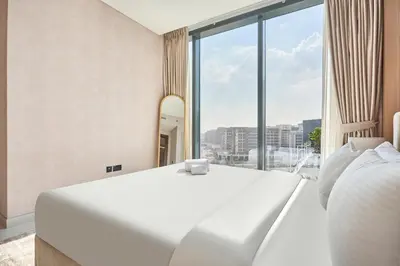 a bedroom with a white bed and a large window at STAY BY LATINEM Luxury 3BR Holiday Home CA 0702 Near Burj Khalifa in Dubai