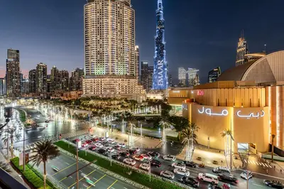 a city skyline at night with cars in a parking lot at Burj khalifa view I Sofa bed I walking distance to Dubai Mall in Dubai