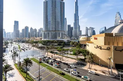 a city with tall buildings and a street with cars at Burj khalifa view I Sofa bed I walking distance to Dubai Mall in Dubai
