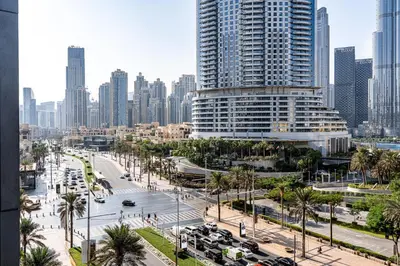 a city with tall buildings and a street with cars at Burj khalifa view I Sofa bed I walking distance to Dubai Mall in Dubai