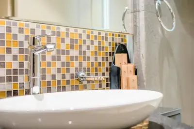 a bathroom with a sink and a tile wall at TRPS - Uppercrest, Downtown - Burj Khalifa View, Furnished, Near Dubai Mall in Dubai
