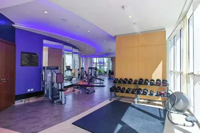a gym with dumbbells and a purple ceiling at TRPS - Uppercrest, Downtown - Burj Khalifa View, Furnished, Near Dubai Mall in Dubai