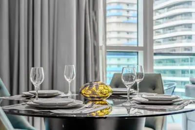 a table with glasses and plates and a bowl on it at TRPS - Uppercrest, Downtown - Burj Khalifa View, Furnished, Near Dubai Mall in Dubai