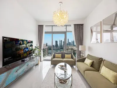 a living room with a couch and a tv at Livin' Holidays - 1 BR - Stunning Private beach in Dubai