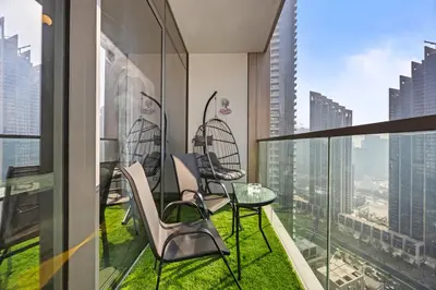a balcony with chairs and a table on top of a building at Versace 1BR Downtown Burj View From Infinity Pool in Dubai