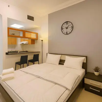 a bedroom with a bed and a clock on the wall at Luxury studio in Dubai Marina in Dubai