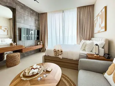 a bedroom with a bed and a table and a couch at Luxe Studio Perch in Binghatti Azure with Pool & Gym in Dubai