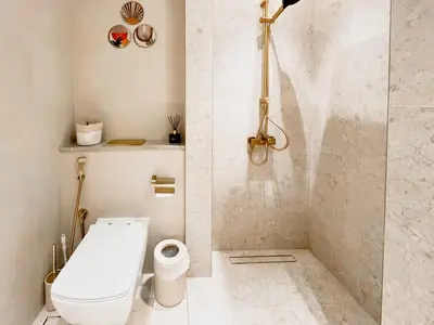 a white bathroom with a toilet and a shower at Luxe Studio Perch in Binghatti Azure with Pool & Gym in Dubai
