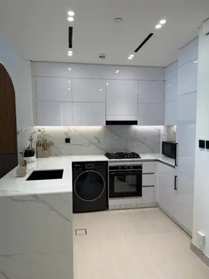a white kitchen with a stove and a dishwasher at High floor luxury apartment JVC in Dubai