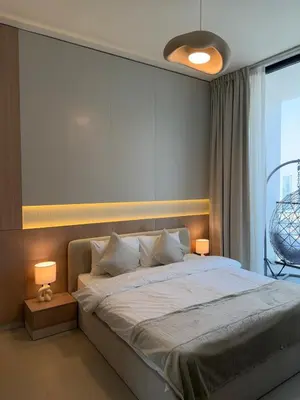 a bedroom with a large bed with two lamps at High floor luxury apartment JVC in Dubai