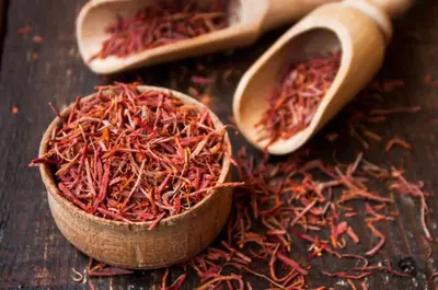 a wooden bowl filled with red spices next to two spoons at Test Property - NoBookings in Dubai