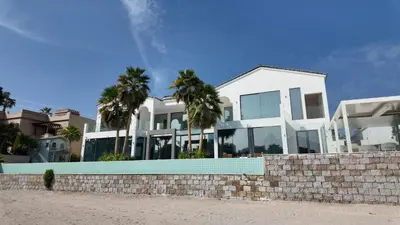 a white house with palm trees in front of it at Signature Palm Villa Exclusive 6 BDR Retreat in Dubai
