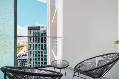 a balcony with two chairs and a view of a city at Restay Homes at Binghatti Azure - Great City Escape - Swimming Pool Access in Dubai