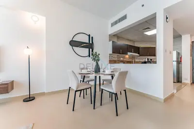 a dining room with a table and chairs at Community View 1BR, Perfect Location Near Miracle Garden, Butterfly Garden and Community Spaces, Orion Building, Arjan by Deluxe Holiday Homes in Dubai