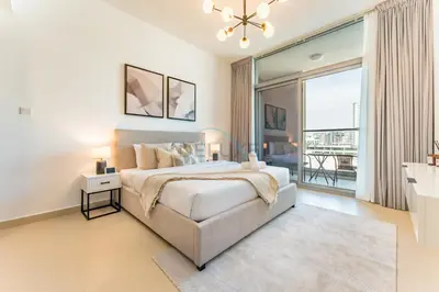 a bedroom with a large bed and a large window at Community View 1BR, Perfect Location Near Miracle Garden, Butterfly Garden and Community Spaces, Orion Building, Arjan by Deluxe Holiday Homes in Dubai