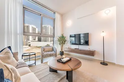 a living room with a couch and a table at Community View 1BR, Perfect Location Near Miracle Garden, Butterfly Garden and Community Spaces, Orion Building, Arjan by Deluxe Holiday Homes in Dubai