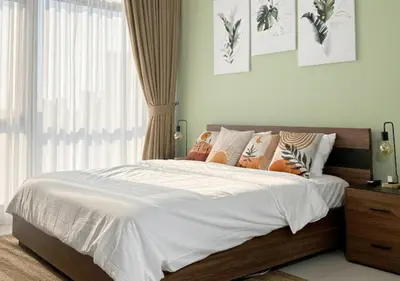 a bedroom with a bed with white sheets and pillows at Modern Studio Apartment with Balcony in JVC in Dubai