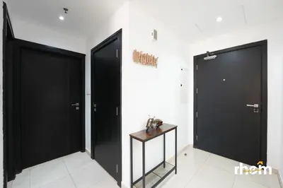 two black doors in a white room with a table at Brand New 2-BR Apartment in Dubai Marina - JBR in Dubai