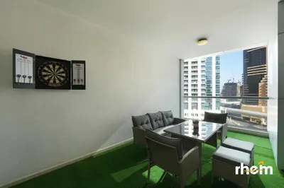 a dining room with a table and a clock on the wall at Brand New 2-BR Apartment in Dubai Marina - JBR in Dubai
