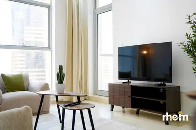 a living room with a flat screen tv on a cabinet at Brand New 2-BR Apartment in Dubai Marina - JBR in Dubai