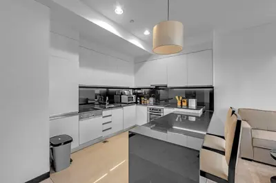 a kitchen with white cabinets and a counter top at Waves - Modern Comfort 1BR Apt at JW Marriott Marina Mall in Dubai
