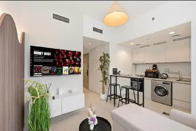 a kitchen and living room with a couch and a table at Modern Flat close to Burj Khalifa with stunning pool in Dubai