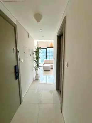 a hallway with a couch and a plant in a room at Modern Flat close to Burj Khalifa with stunning pool in Dubai