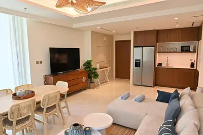 a living room with a couch and a tv and a table at Luxury 2BR Private Beach Partial Sea View in Dubai