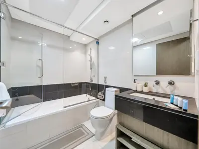 a bathroom with a toilet and a tub and a sink at 2BR Panoramic City - Burj and Fountain View in Dubai