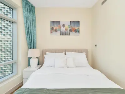 a bedroom with a white bed and a window at 2BR Panoramic City - Burj and Fountain View in Dubai