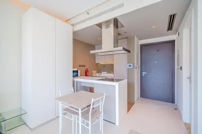 a kitchen with a wooden table and chairs in a room at Modern Studio with Skyline Views in Dubai Marina in Dubai