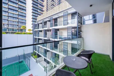 an apartment balcony with two chairs and a table at Easy access to Community Parks and Green Spaces,15 minutes drive to Miracle Garden - Rigel, JVC, by Deluxe Holiday Homes in Dubai