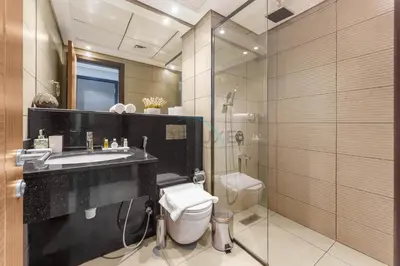 a bathroom with a toilet and a sink and a shower at Easy access to Community Parks and Green Spaces,15 minutes drive to Miracle Garden - Rigel, JVC, by Deluxe Holiday Homes in Dubai