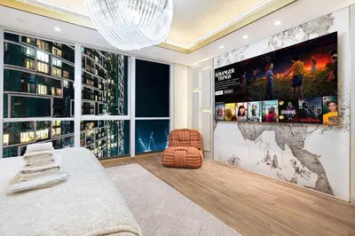 a living room with a large flat screen tv on a wall at Sky Palace 3 Bedroom Penthouse on JBR in Dubai