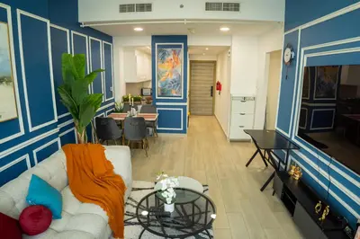 a living room with a couch and a tv at Bloom Tower B-Stunning View-Luxurious Furnish-Pool View in Dubai