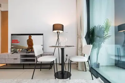 a living room with a table and chairs and a tv at Luxury 1 Bed Address JBR Direct Beachfront Living in Dubai