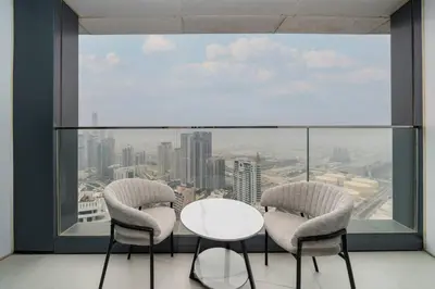 a table and two chairs in front of a large window at Luxury 1 Bed Address JBR Direct Beachfront Living in Dubai