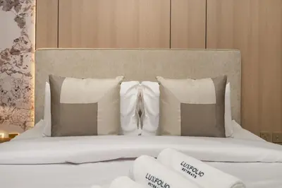 a bed with white pillows and towels on it at Stylish Modern Peninsula One Studio, Business Bay in Dubai