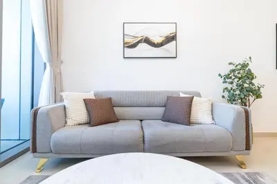 a living room with a gray couch with pillows at Stylish 1 Bed in Downtown with Dubai Mall Access in Dubai