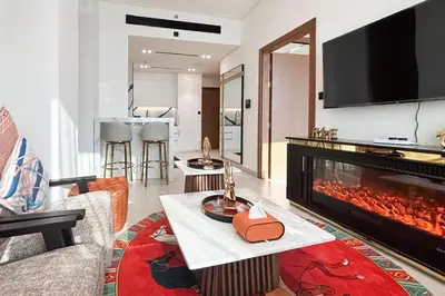 a living room with a fireplace and a couch at Modern Place - Trillionaire Residence 608 in Dubai