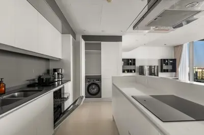 a kitchen with white counters and a washing machine at Modern 2BDR in Bluewaters Beach&Pool in Dubai