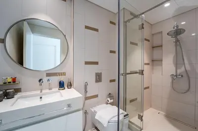 a bathroom with a shower and a sink and a mirror at 2BR with Atlantis View, Beach Access, and Infinity Pool in Dubai