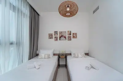 two twin beds in a room with a window at 2BR with Atlantis View, Beach Access, and Infinity Pool in Dubai