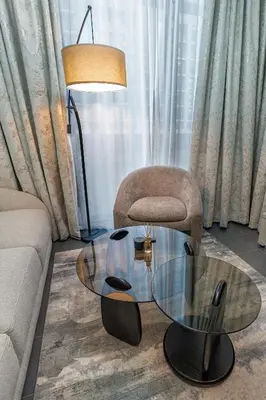 a living room with a glass coffee table and a chair at Stylish Flat in Dubai in Dubai