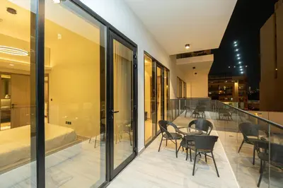a glass balcony with a table and chairs on it at Venetian - Elegant 1BR in JVC & Perfect for Work Leisure in Dubai