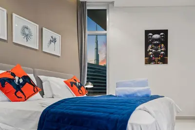 a bedroom with a bed with blue and orange pillows at Luxury Apartment with canal view - near to Burj Khalifa - Dubai in Dubai