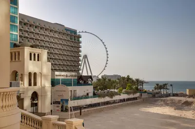 a hotel on the beach with a ferris wheel in the background at Frank Porter - Bahar 6 in Dubai