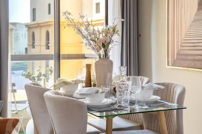 a dining room table with a vase of flowers on it at Frank Porter - Bahar 6 in Dubai